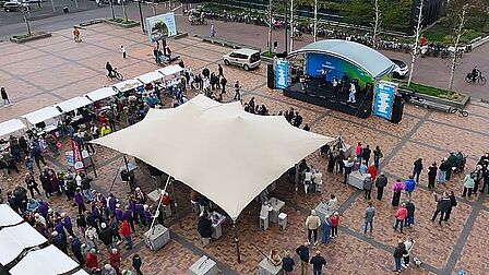Bovenaanzicht van het podium, met toeschouwers en kraampjes