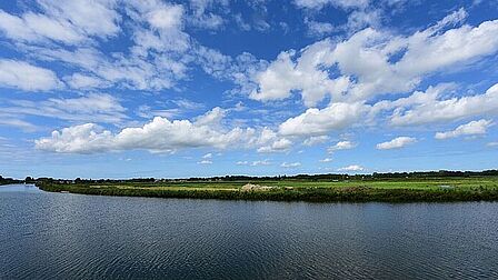 Water, weiland en een blauwe lucht in Kanaalpark.