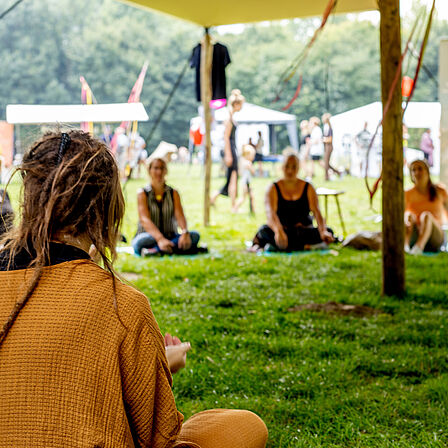 Sfeerfoto op het festival: festivalbezoekers zitten in een kring.