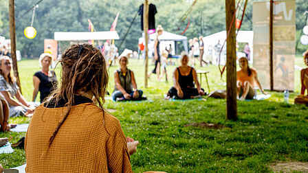 Sfeerfoto op het festival: festivalbezoekers zitten in een kring.