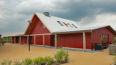 Foto van het rode gebouw van activiteitencentrum Het Erf